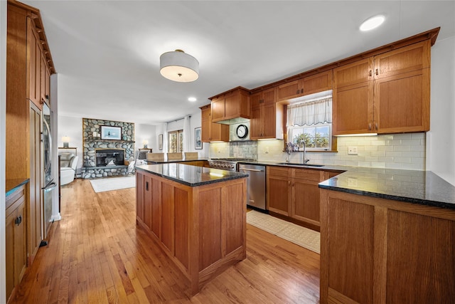 kitchen with sink, plenty of natural light, stainless steel dishwasher, and light wood-type flooring