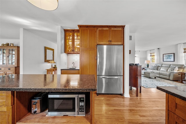 kitchen featuring tasteful backsplash, appliances with stainless steel finishes, a center island, and light hardwood / wood-style floors