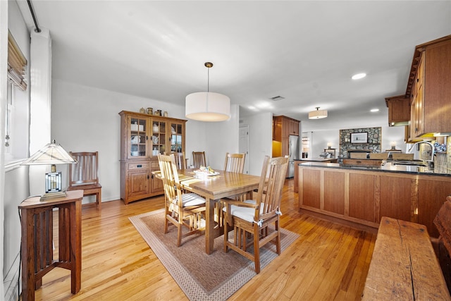 dining area with sink and light hardwood / wood-style flooring