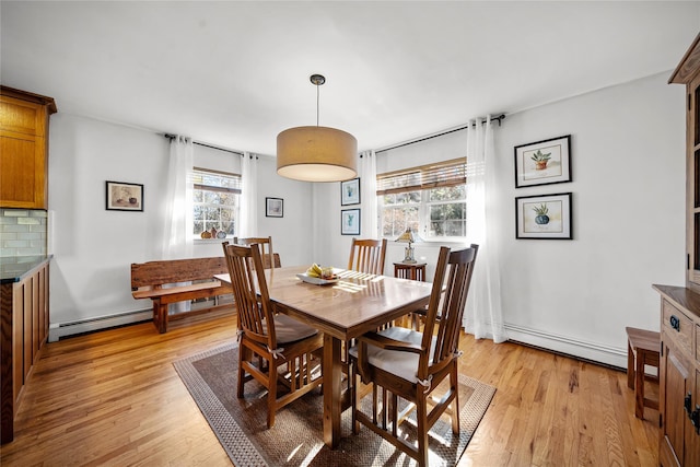 dining space featuring a baseboard radiator and light hardwood / wood-style flooring