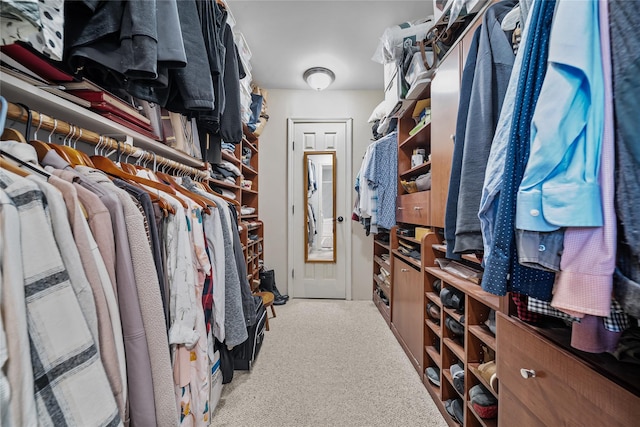 walk in closet featuring light colored carpet