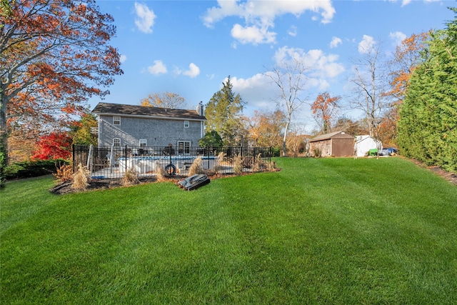 view of yard with an empty pool and a storage shed