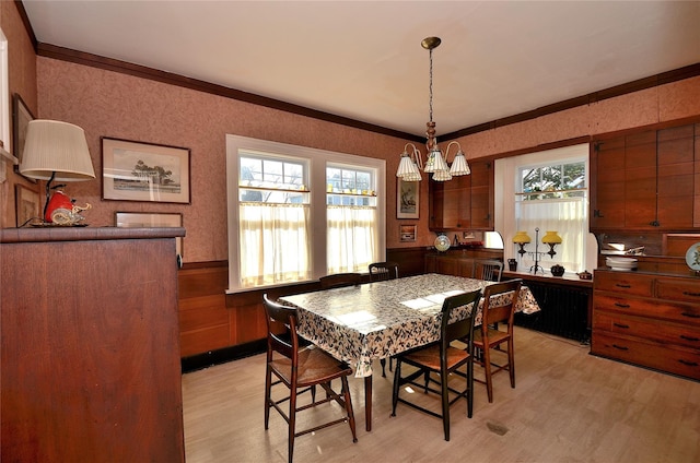 dining room featuring light hardwood / wood-style floors, crown molding, and a chandelier