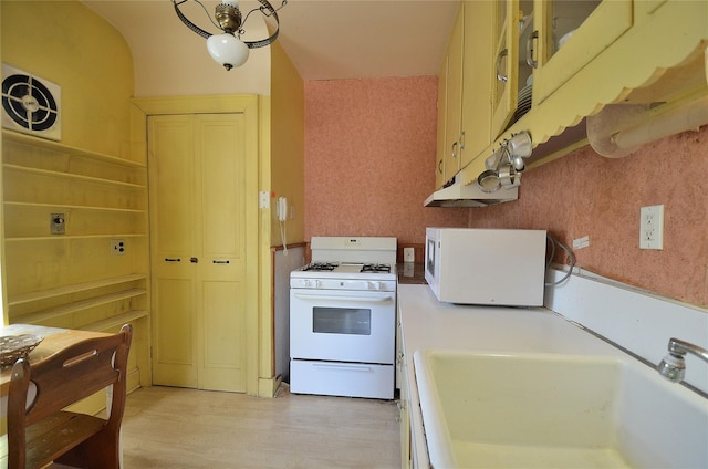 kitchen with sink, white appliances, and light wood-type flooring