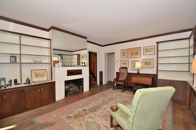 living room with dark hardwood / wood-style floors, ornamental molding, and a tiled fireplace