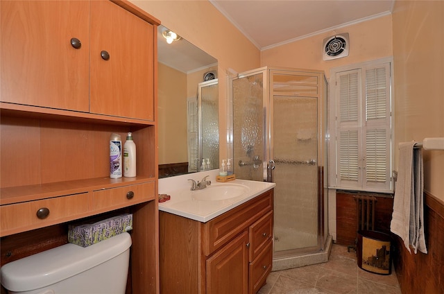 bathroom featuring vanity, toilet, a shower with door, and ornamental molding