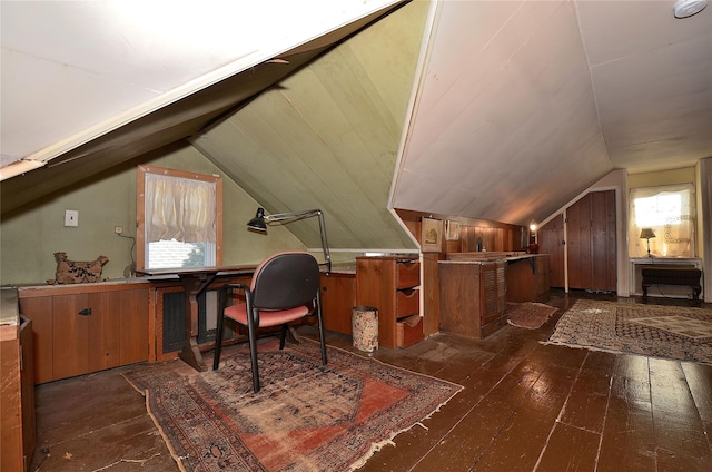 office space with wood walls, dark wood-type flooring, and lofted ceiling