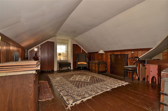 interior space featuring dark hardwood / wood-style flooring, lofted ceiling, and wood walls