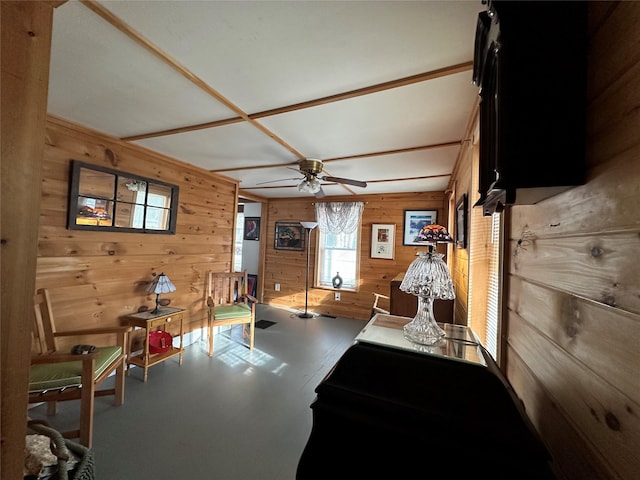 interior space with ceiling fan and wood walls