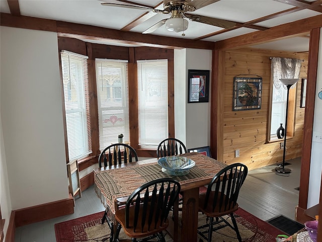 dining space with wood walls, light hardwood / wood-style flooring, and ceiling fan