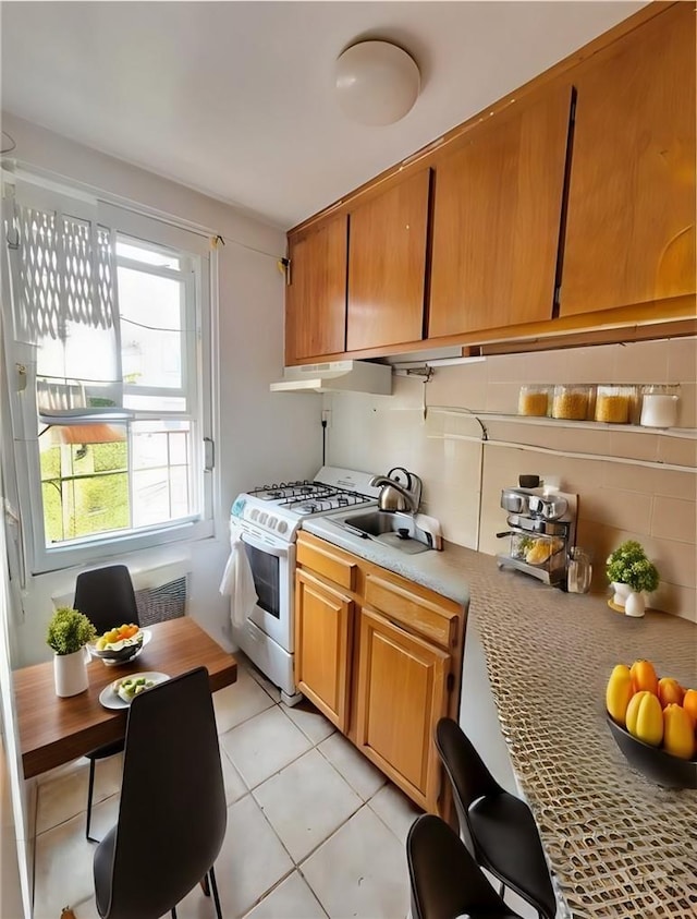 kitchen with sink, light tile patterned floors, and white range with gas stovetop