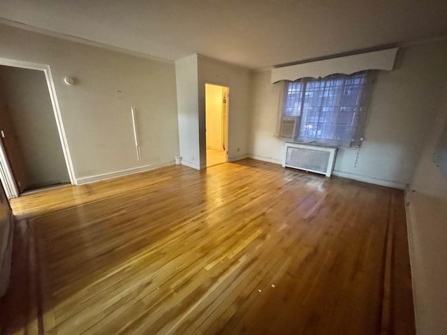 empty room with radiator heating unit and hardwood / wood-style flooring