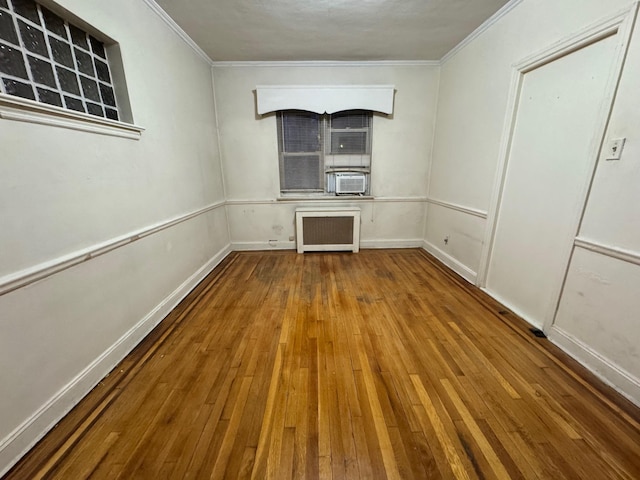 spare room with crown molding, cooling unit, hardwood / wood-style flooring, and radiator heating unit