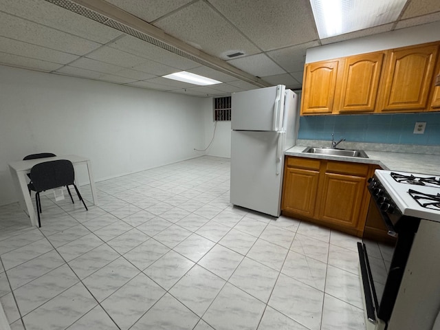 kitchen featuring a paneled ceiling, sink, and white appliances