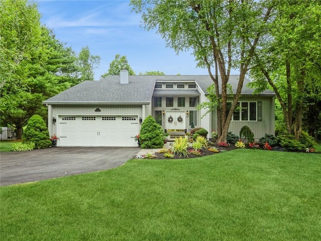 view of front of property featuring a front yard and a garage