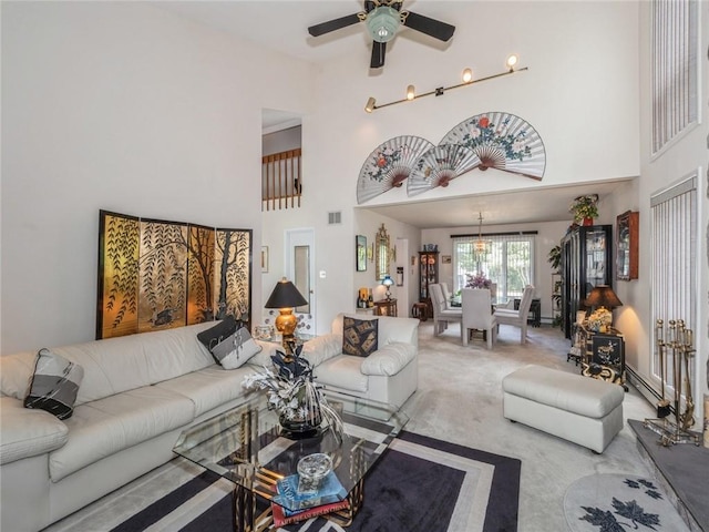 carpeted living room with a towering ceiling and ceiling fan