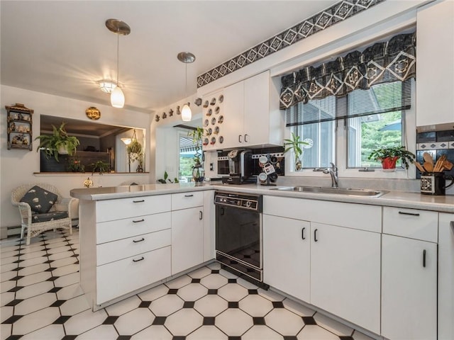 kitchen featuring kitchen peninsula, white cabinets, sink, pendant lighting, and dishwasher