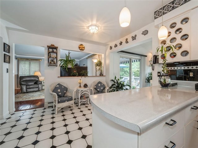 kitchen featuring baseboard heating, white cabinets, and decorative light fixtures