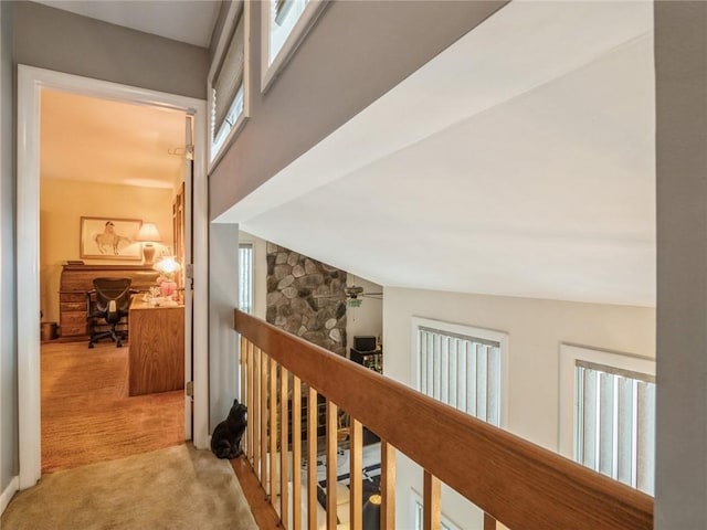 corridor with light colored carpet and lofted ceiling