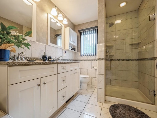 bathroom with vanity, decorative backsplash, toilet, walk in shower, and tile walls