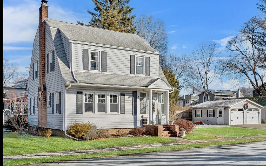 view of property featuring an outbuilding, a garage, and a front yard