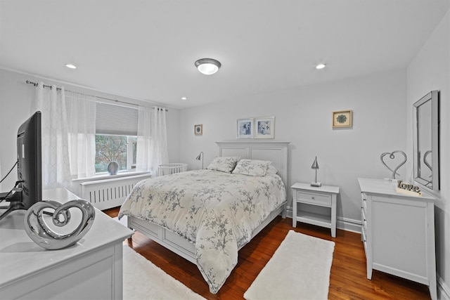 bedroom featuring radiator heating unit and dark hardwood / wood-style floors