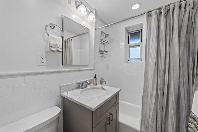 full bathroom with vanity, tile walls, shower / tub combo with curtain, and toilet