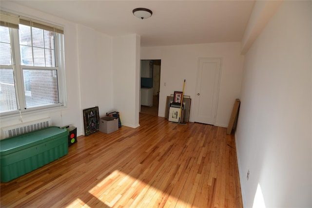 empty room featuring radiator and light hardwood / wood-style floors