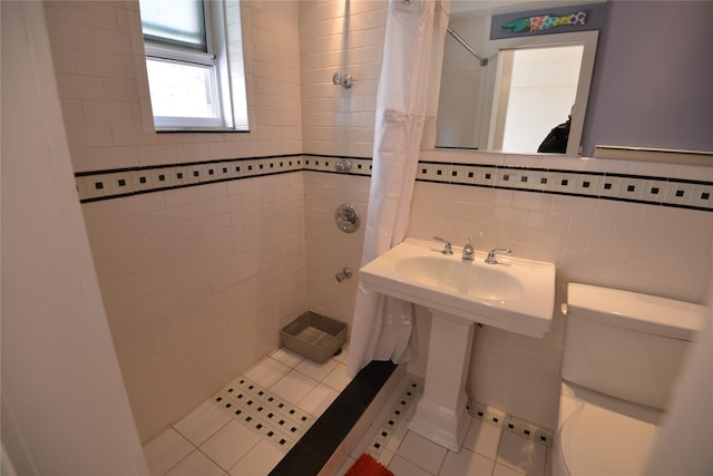 bathroom with tile patterned floors, a shower with curtain, toilet, tile walls, and tasteful backsplash