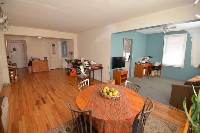 dining space with ceiling fan and light hardwood / wood-style flooring