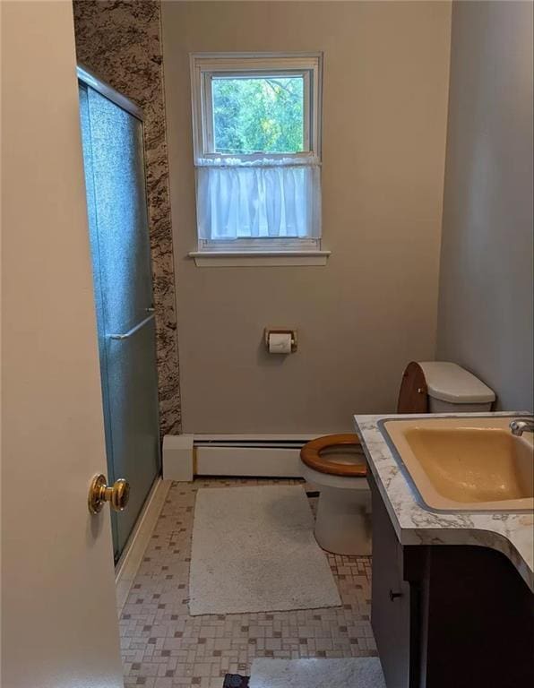 bathroom with vanity, a shower with door, tile patterned floors, toilet, and a baseboard radiator