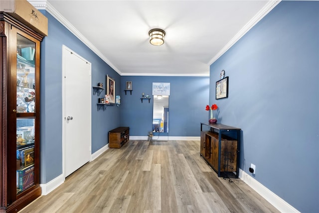 hall with light hardwood / wood-style flooring and ornamental molding