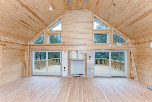 unfurnished living room with hardwood / wood-style floors and wood walls