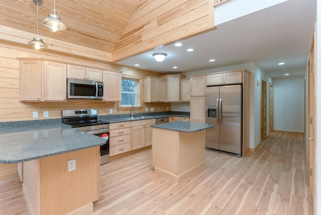 kitchen featuring appliances with stainless steel finishes, sink, light hardwood / wood-style flooring, a kitchen island, and lofted ceiling