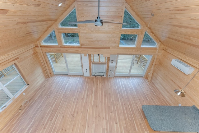 unfurnished living room featuring wood walls, hardwood / wood-style floors, and high vaulted ceiling