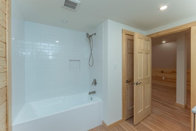 bathroom featuring hardwood / wood-style flooring and tiled shower / bath