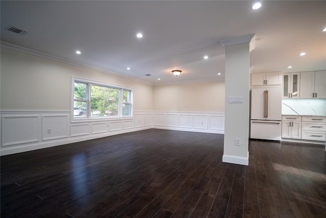 spare room featuring ornamental molding and dark wood-type flooring