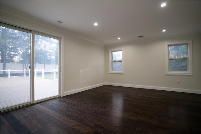 empty room with dark hardwood / wood-style floors, plenty of natural light, and crown molding