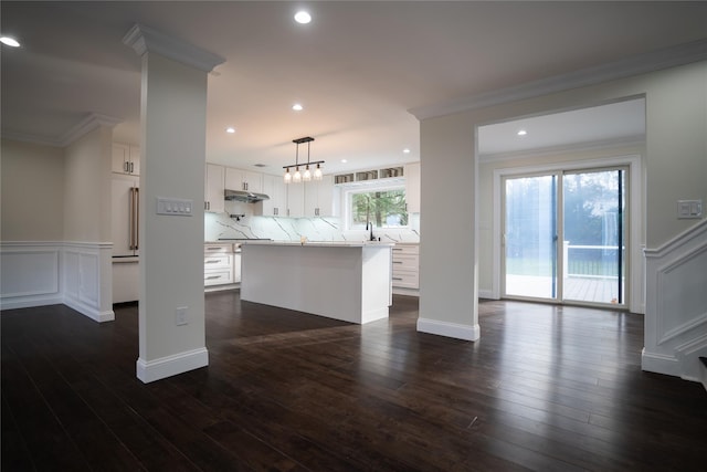 kitchen with a center island, hanging light fixtures, dark hardwood / wood-style floors, tasteful backsplash, and white cabinetry