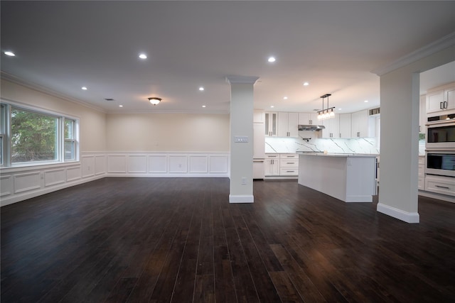 unfurnished living room with crown molding and dark hardwood / wood-style floors