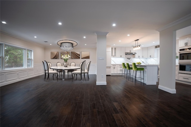 unfurnished dining area featuring recessed lighting, dark wood-style floors, ornamental molding, and a decorative wall