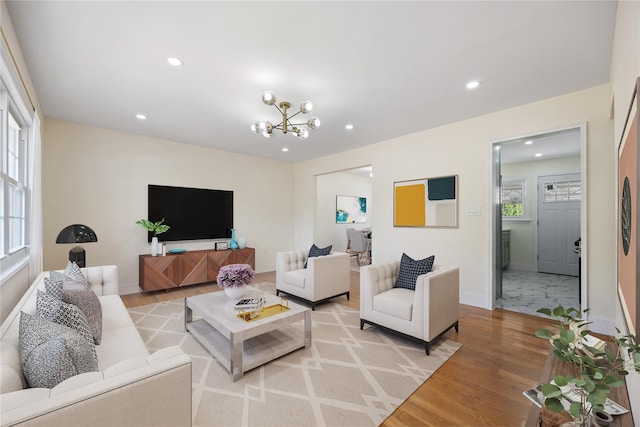 living room featuring a chandelier and light wood-type flooring