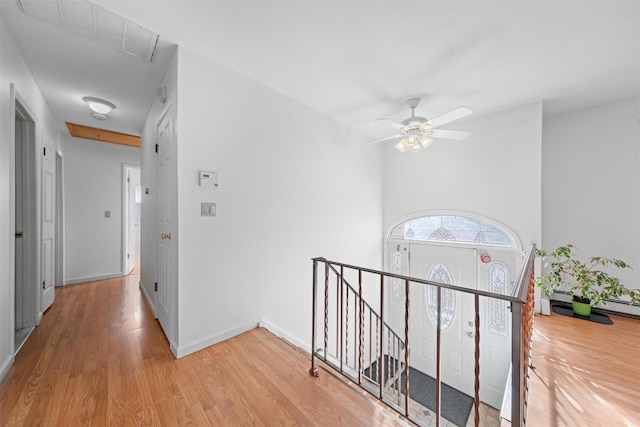 hallway with baseboard heating and light hardwood / wood-style floors