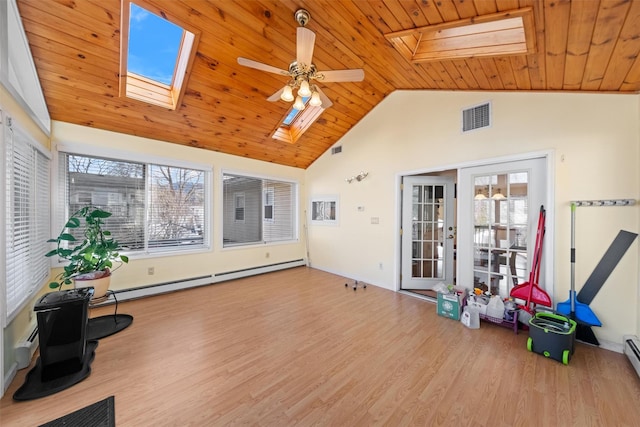 sunroom featuring ceiling fan, wood ceiling, baseboard heating, and lofted ceiling with skylight