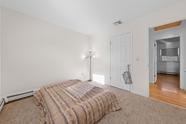 carpeted bedroom featuring a baseboard heating unit