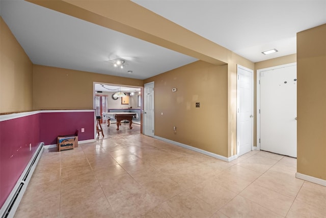 tiled empty room with a baseboard radiator and billiards