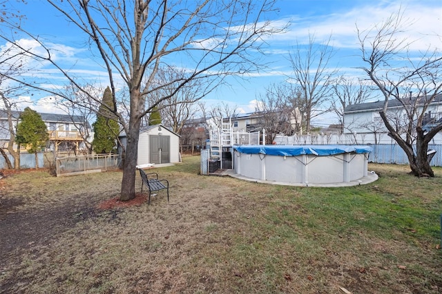 view of yard featuring a covered pool and a storage unit