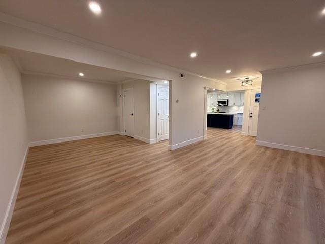 unfurnished living room featuring hardwood / wood-style floors and ornamental molding