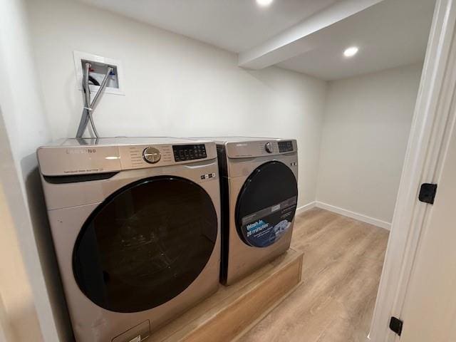 laundry area featuring light wood-type flooring and separate washer and dryer