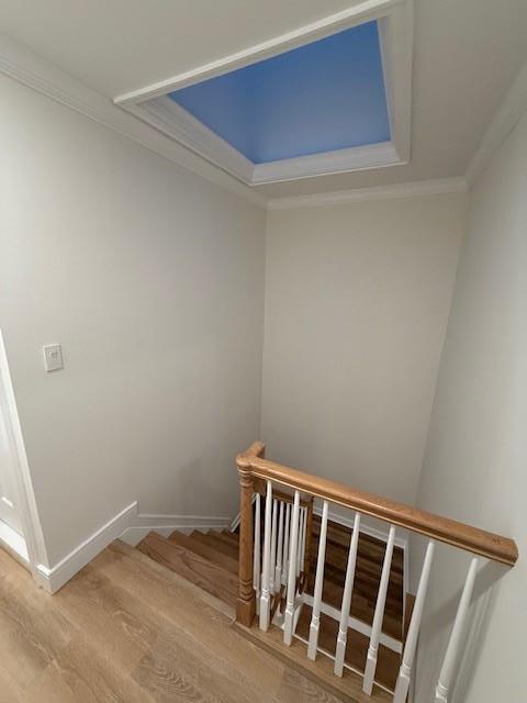 stairway featuring hardwood / wood-style flooring and crown molding